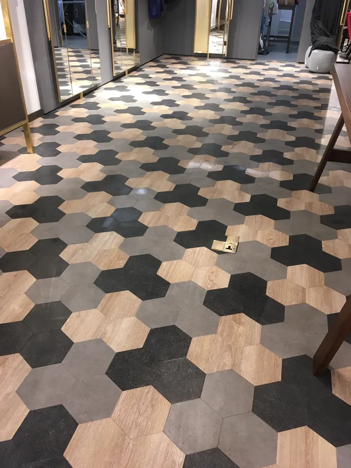 Black, grey and wood-effect hexagonal LVT flooring in a commercial property