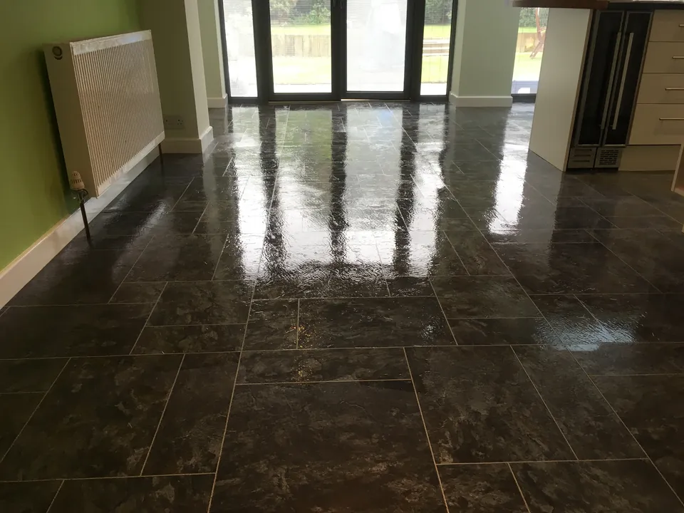 Newly restored dark Karndean kitchen floor reflecting light from patio doors